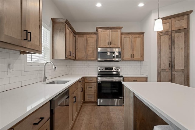 24840 W 178th Ct, Gardner, KS 66030 - kitchen with stainless steel appliances, wood finished floors, pendant lighting, light countertops, and tasteful backsplash
