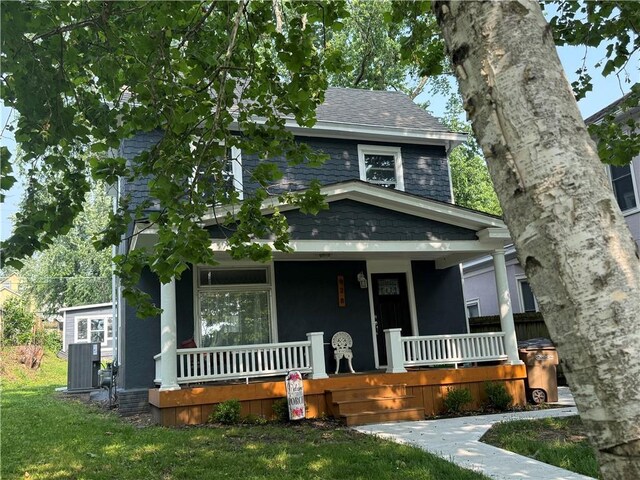 928 S 6th St, Atchison, KS 66002 - traditional style home with a porch, a shingled roof, and a front lawn