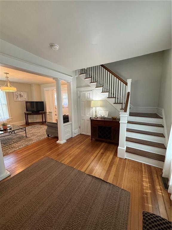 928 S 6th St, Atchison, KS 66002 - stairway with hardwood / wood-style flooring and decorative columns