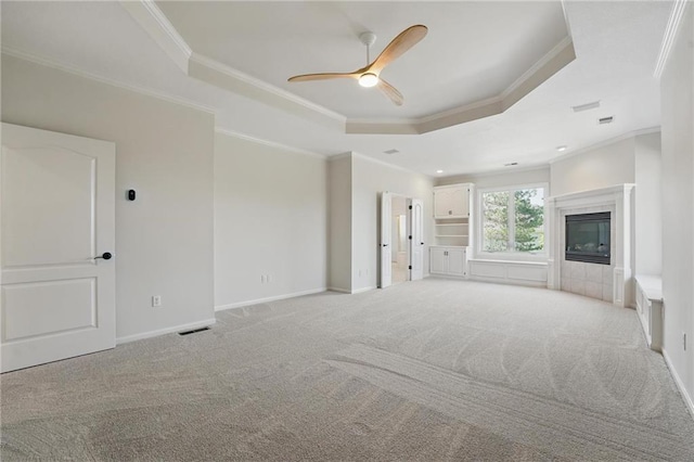 15340 Knox St, Overland Park, KS 66221 - unfurnished living room featuring a tray ceiling, crown molding, ceiling fan, light colored carpet, and a fireplace