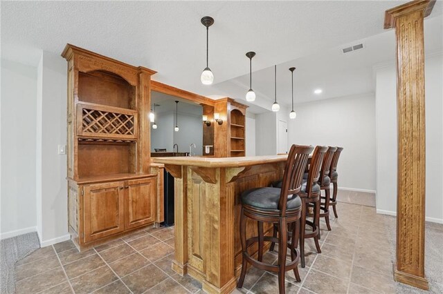 15340 Knox St, Overland Park, KS 66221 - indoor wet bar with pendant lighting, tile patterned floors, ornate columns, and recessed lighting