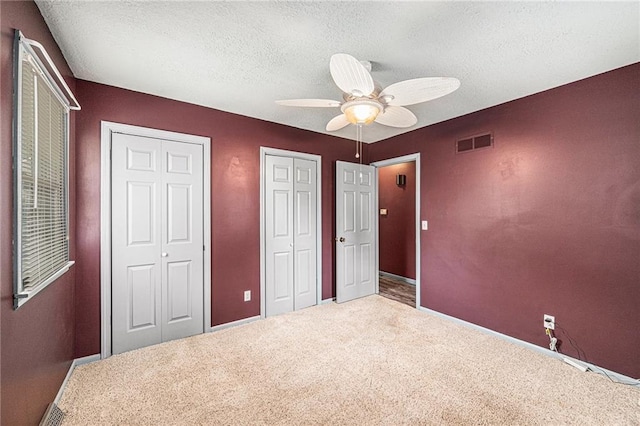 308 E Meadow St, Smithville, MO 64089 - unfurnished bedroom with two closets, carpet flooring, a textured ceiling, and ceiling fan