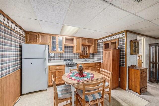 308 E Meadow St, Smithville, MO 64089 - kitchen with freestanding refrigerator, range, wallpapered walls, a paneled ceiling, and light floors