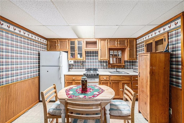 308 E Meadow St, Smithville, MO 64089 - kitchen featuring white appliances, wallpapered walls, a paneled ceiling, light flooring, and a wainscoted wall