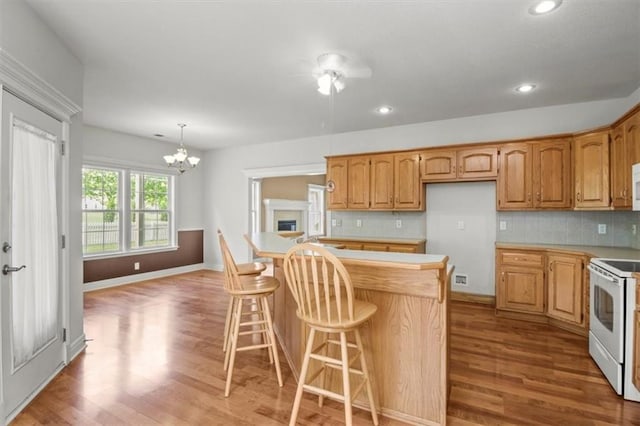 1111 SW 13th St, Oak Grove, MO 64075 - kitchen featuring white appliances, light wood-style flooring, light countertops, a chandelier, and backsplash