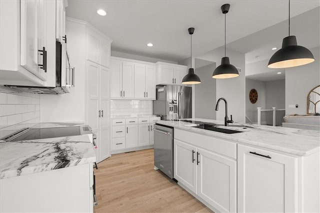 1104 SW Magnolia Cir, Oak Grove, MO 64075 - kitchen featuring stainless steel appliances, recessed lighting, light wood-style floors, tasteful backsplash, and white cabinetry
