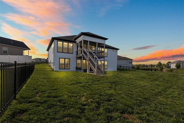 1104 SW Magnolia Cir, Oak Grove, MO 64075 - back of property at dusk with stairs and a fenced backyard