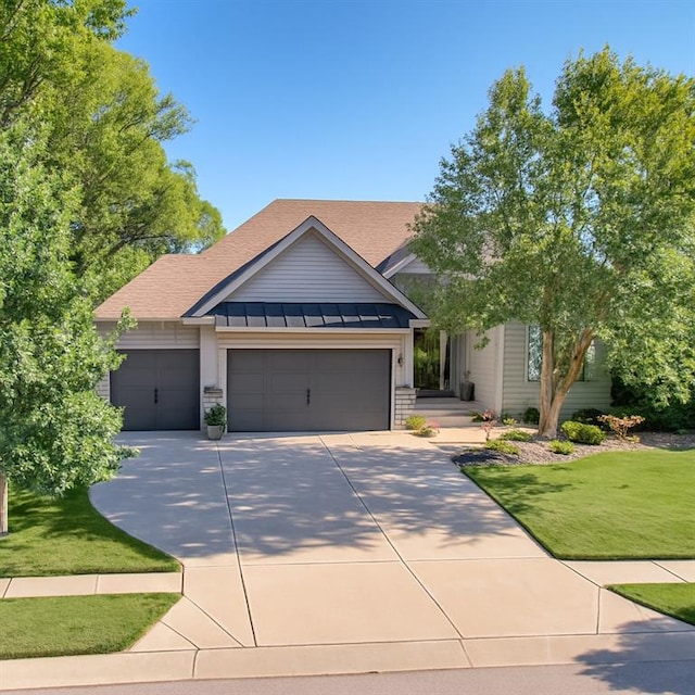 15882 W 165th Ter, Olathe, KS 66062 - view of front facade with an attached garage, concrete driveway, a front lawn, a shingled roof, and a standing seam roof