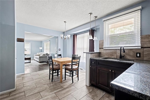 5011 Briar St, Roeland Park, KS 66205 - kitchen with a chandelier, pendant lighting, a textured ceiling, open floor plan, and tasteful backsplash