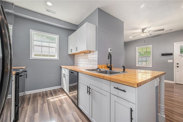 815 Pawnee St, Leavenworth, KS 66048 - kitchen with dishwashing machine, fridge, dark wood finished floors, black / electric stove, and a peninsula