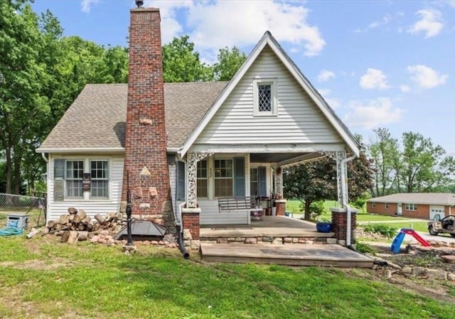 402 Fifth St, Smithville, MO 64089 - back of house featuring a chimney, a porch, and roof with shingles