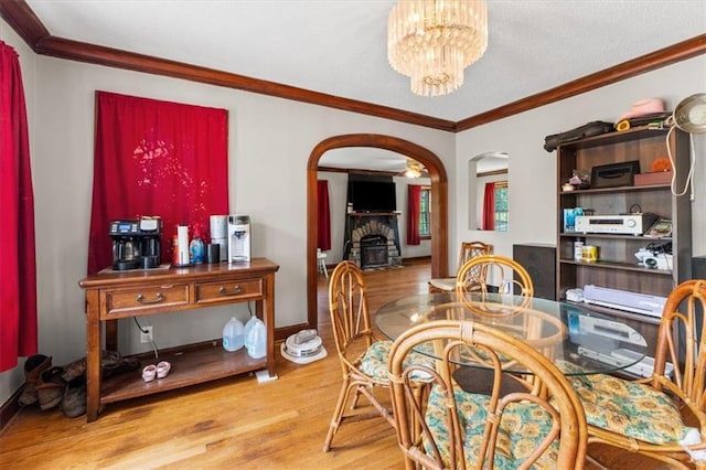 402 Fifth St, Smithville, MO 64089 - dining room featuring arched walkways, light wood-type flooring, a chandelier, and crown molding