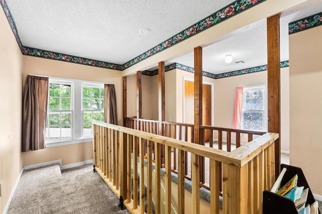 402 Fifth St, Smithville, MO 64089 - hallway featuring an upstairs landing, a textured ceiling, plenty of natural light, and carpet flooring