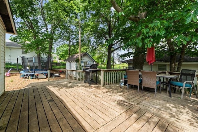 402 Fifth St, Smithville, MO 64089 - wooden deck featuring a trampoline, a shed, and area for grilling