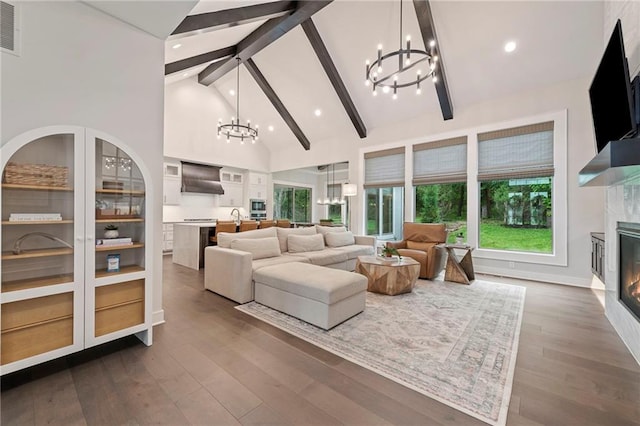 11807 S Kenton St, Olathe, KS 66061 - living room featuring a chandelier, a glass covered fireplace, beamed ceiling, high vaulted ceiling, and plenty of natural light