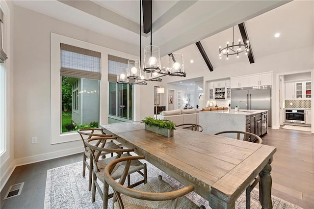 11807 S Kenton St, Olathe, KS 66061 - dining area featuring a chandelier, dark wood finished floors, beam ceiling, recessed lighting, and high vaulted ceiling