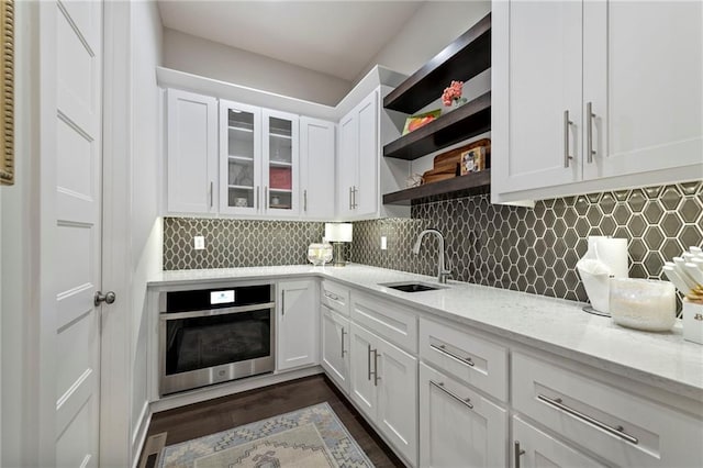11807 S Kenton St, Olathe, KS 66061 - kitchen featuring oven, open shelves, white cabinetry, decorative backsplash, and light stone counters