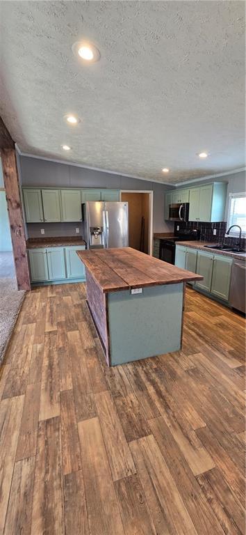 2251 Nemaha Rd, Cummings, KS 66016 - kitchen with green cabinetry, butcher block countertops, appliances with stainless steel finishes, dark wood finished floors, and a textured ceiling
