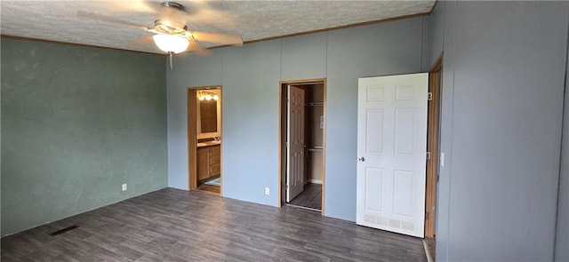 2251 Nemaha Rd, Cummings, KS 66016 - unfurnished bedroom featuring a walk in closet, a textured ceiling, wood finished floors, connected bathroom, and a closet
