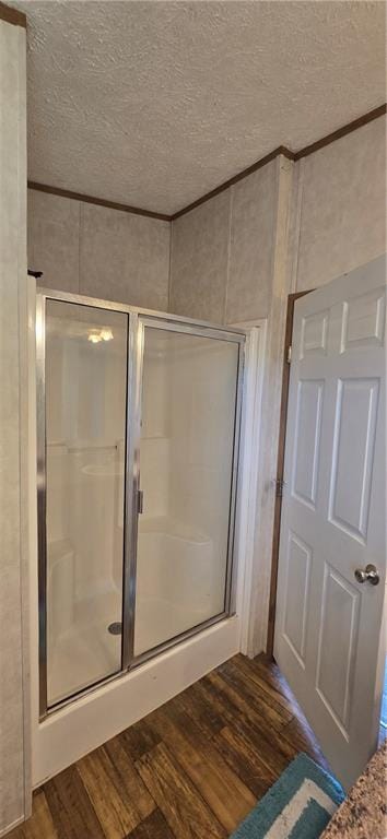 2251 Nemaha Rd, Cummings, KS 66016 - full bathroom with wood finished floors, a shower stall, a textured ceiling, and ornamental molding