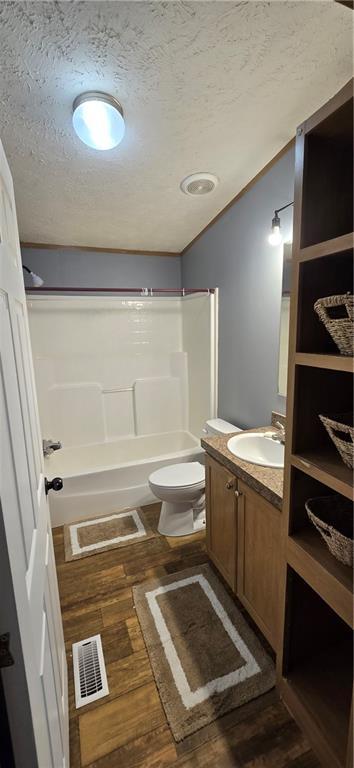 2251 Nemaha Rd, Cummings, KS 66016 - full bathroom featuring a textured ceiling, vanity, bathing tub / shower combination, and wood finished floors