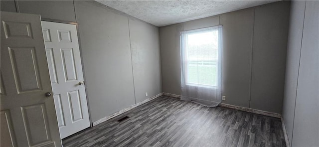 2251 Nemaha Rd, Cummings, KS 66016 - spare room featuring a textured ceiling and dark wood-style floors