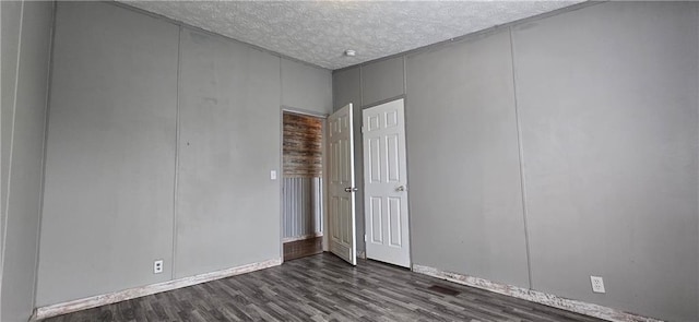 2251 Nemaha Rd, Cummings, KS 66016 - unfurnished room with a textured ceiling, dark wood-style floors, and a decorative wall