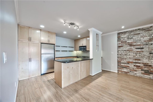 5008 Baltimore Ave Unit 102, Kansas City, MO 64112 - kitchen featuring appliances with stainless steel finishes, dark countertops, recessed lighting, light wood finished floors, and a peninsula