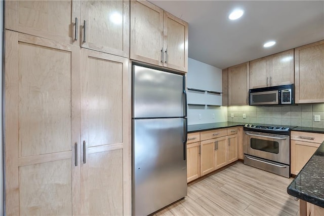 5008 Baltimore Ave Unit 102, Kansas City, MO 64112 - kitchen with appliances with stainless steel finishes, light brown cabinetry, backsplash, light wood finished floors, and recessed lighting