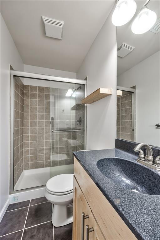 5008 Baltimore Ave Unit 102, Kansas City, MO 64112 - full bath featuring vanity, tile patterned floors, and a stall shower