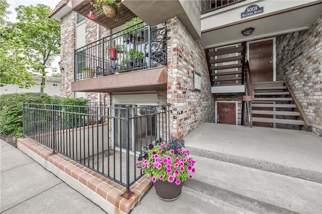 5008 Baltimore Ave Unit 102, Kansas City, MO 64112 - entrance to property with a balcony, brick siding, and a garage