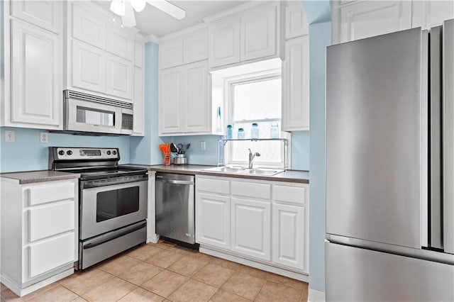 111 E Ruby Ave, Independence, MO 64050 - kitchen with appliances with stainless steel finishes, white cabinetry, light tile patterned floors, and a ceiling fan