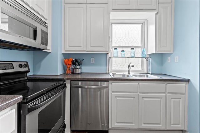111 E Ruby Ave, Independence, MO 64050 - kitchen featuring stainless steel appliances, white cabinetry, and dark countertops