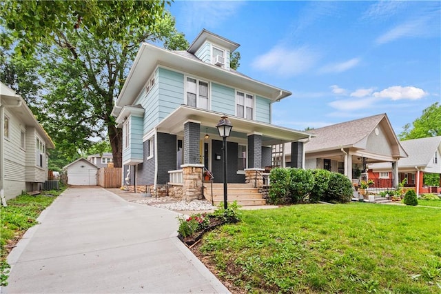 111 E Ruby Ave, Independence, MO 64050 - american foursquare style home with a porch, a front yard, an outdoor structure, and a garage