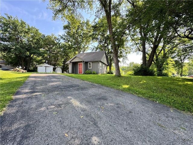 110 W 7th St, Knob Noster, MO 65336 - view of front of home featuring a front yard, a garage, and a storage unit