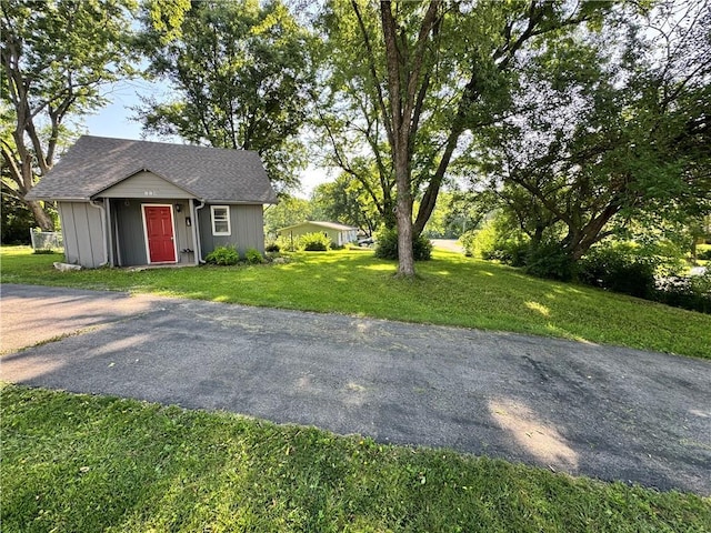 110 W 7th St, Knob Noster, MO 65336 - view of front facade featuring a front lawn, an outbuilding, and a shingled roof