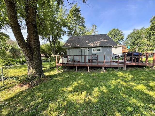 110 W 7th St, Knob Noster, MO 65336 - back of property with a fenced backyard, a wooden deck, board and batten siding, and roof with shingles