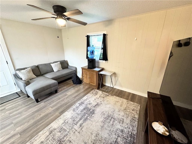 110 W 7th St, Knob Noster, MO 65336 - living area featuring a ceiling fan, wood finished floors, and a textured ceiling