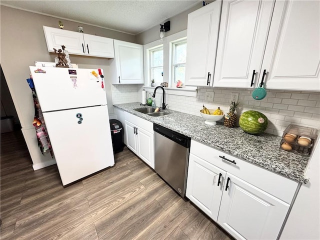 110 W 7th St, Knob Noster, MO 65336 - kitchen featuring stainless steel dishwasher, freestanding refrigerator, light stone countertops, white cabinets, and light wood finished floors