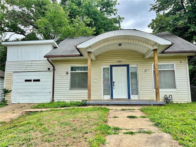 522 S 2nd St, Independence, KS 67301 - view of front facade featuring a shingled roof, a garage, and driveway