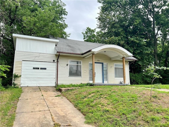 522 S 2nd St, Independence, KS 67301 - view of front facade with a garage, driveway, roof with shingles, and a front yard
