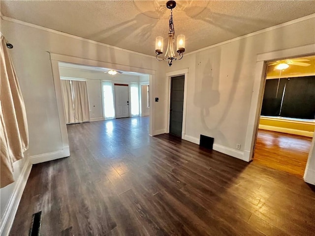 522 S 2nd St, Independence, KS 67301 - unfurnished dining area featuring a ceiling fan, ornamental molding, dark wood-style floors, a textured ceiling, and a chandelier