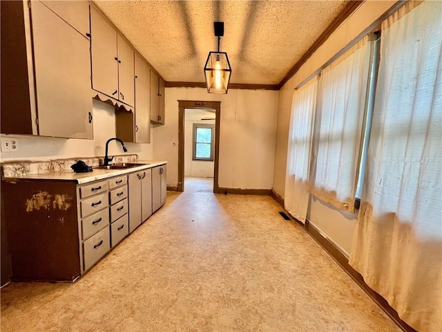 522 S 2nd St, Independence, KS 67301 - kitchen with light countertops, ornamental molding, a textured ceiling, and pendant lighting