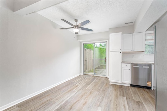 4612 Whispering Winds Dr Unit B, Lees Summit, MO 64064 - kitchen with stainless steel dishwasher, light wood-type flooring, a textured ceiling, healthy amount of natural light, and white cabinetry