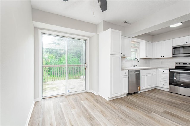 4612 Whispering Winds Dr Unit B, Lees Summit, MO 64064 - kitchen featuring stainless steel appliances, light wood-style flooring, light countertops, and white cabinetry