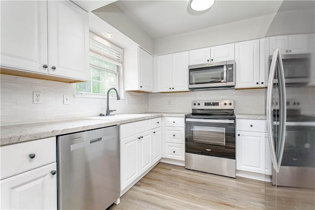 4612 Whispering Winds Dr Unit B, Lees Summit, MO 64064 - kitchen featuring appliances with stainless steel finishes, white cabinets, decorative backsplash, and light stone counters