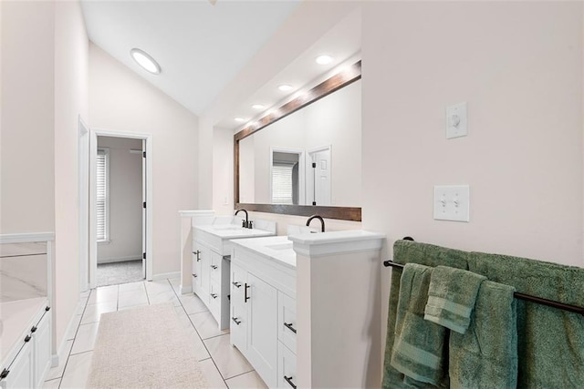 2433 Post Oak Rd, Olathe, KS 66061 - bathroom featuring double vanity, vaulted ceiling, tile patterned flooring, recessed lighting, and healthy amount of natural light