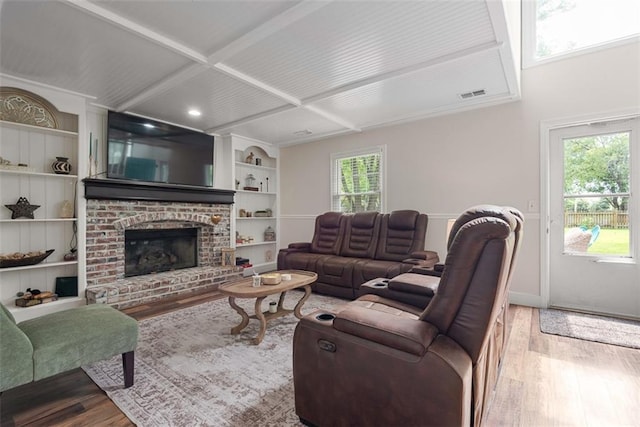 2433 Post Oak Rd, Olathe, KS 66061 - living room with wood finished floors, built in shelves, and a brick fireplace