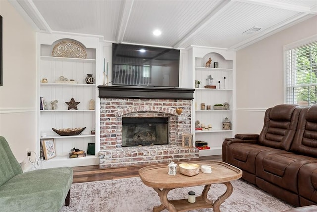 2433 Post Oak Rd, Olathe, KS 66061 - living area featuring built in shelves, wood finished floors, and a brick fireplace
