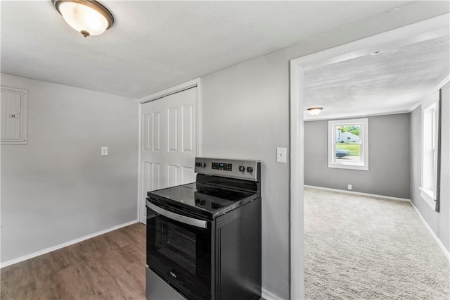 1202 E 23rd St S, Independence, MO 64055 - kitchen with stainless steel electric range, electric panel, a textured ceiling, and wood finished floors